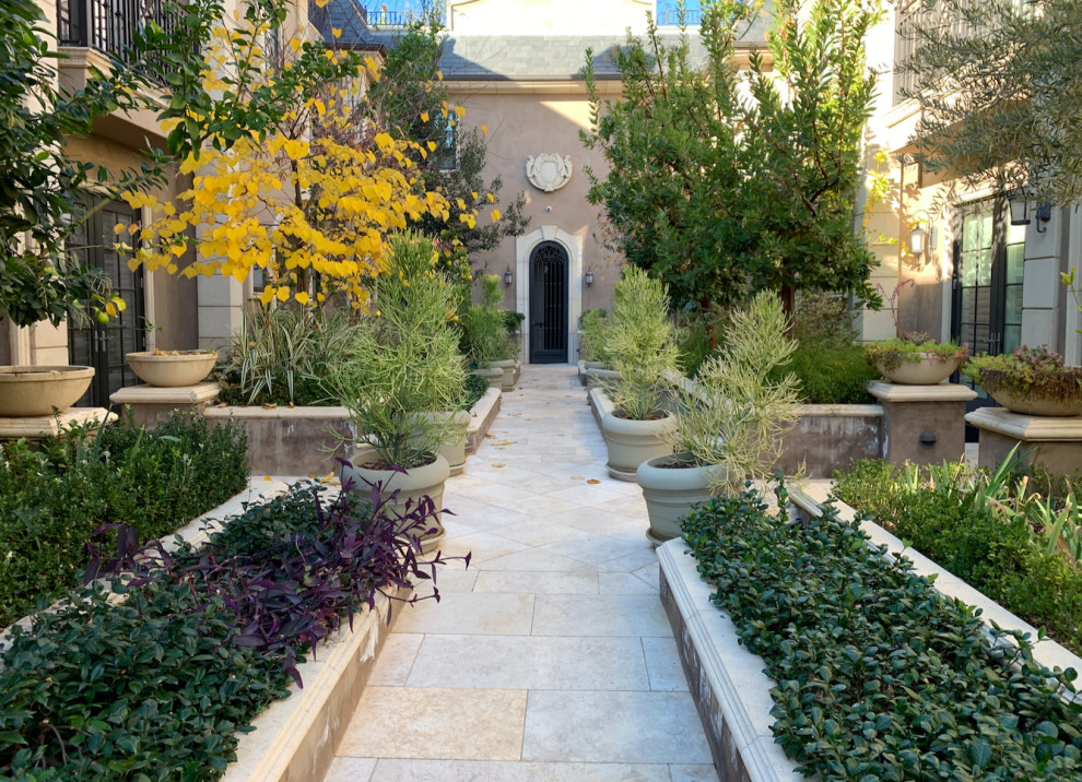 Idee per un grande patio o portico in cortile con un giardino in vaso, pavimentazioni in pietra naturale e nessuna copertura