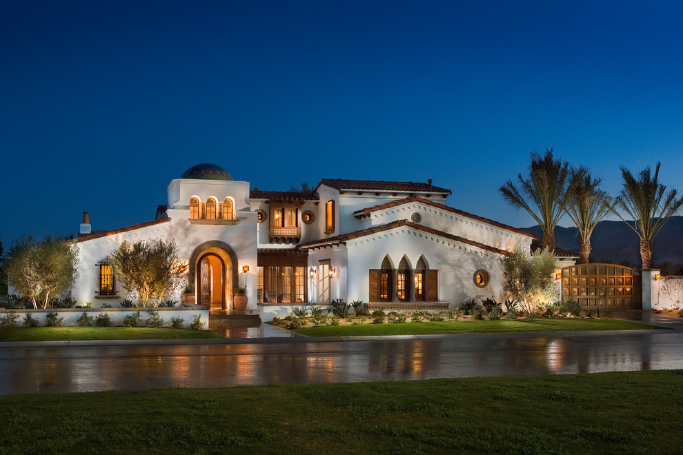 Inspiration for a mediterranean two-storey white house exterior in Orange County with a gable roof and a tile roof.