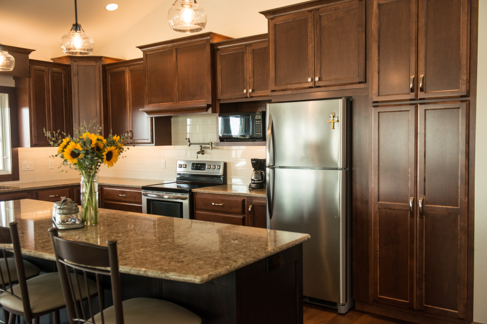 Inspiration for a large transitional l-shaped medium tone wood floor open concept kitchen remodel with an undermount sink, flat-panel cabinets, medium tone wood cabinets, quartz countertops, white backsplash, ceramic backsplash, stainless steel appliances, an island and multicolored countertops