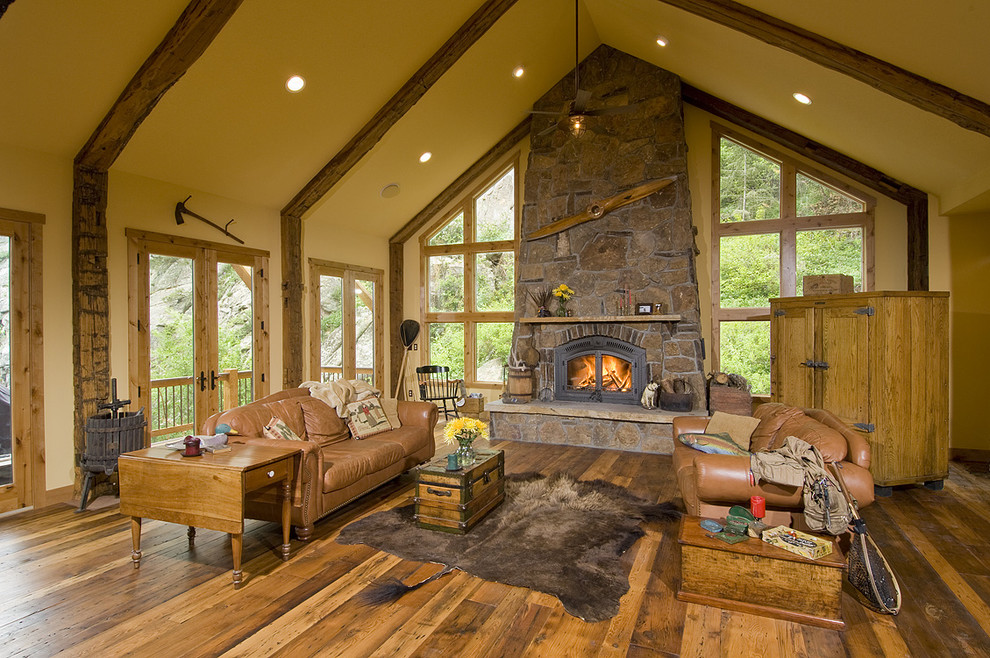 Mid-sized country formal open concept living room in Denver with a stone fireplace surround, beige walls, dark hardwood floors, a standard fireplace and no tv.
