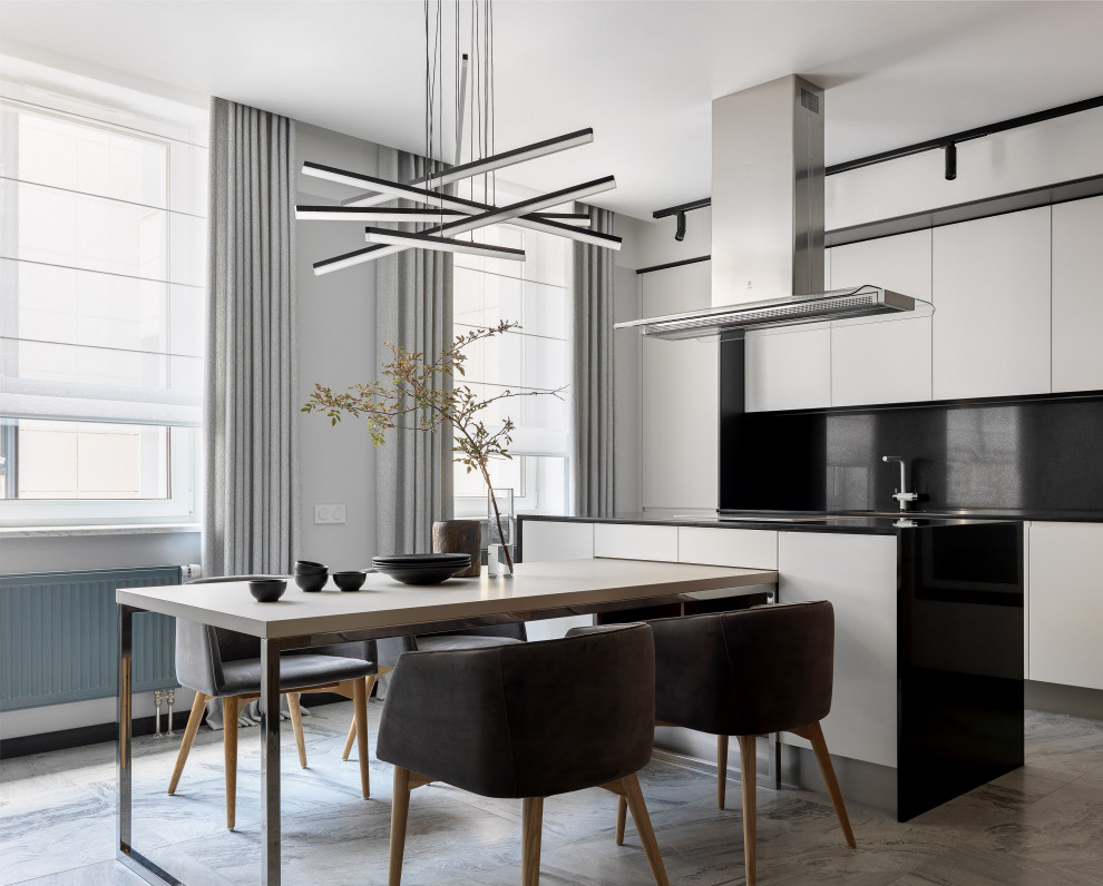 Photo of a contemporary eat-in kitchen in Moscow with flat-panel cabinets, white cabinets, black splashback, with island, grey floor and black benchtop.