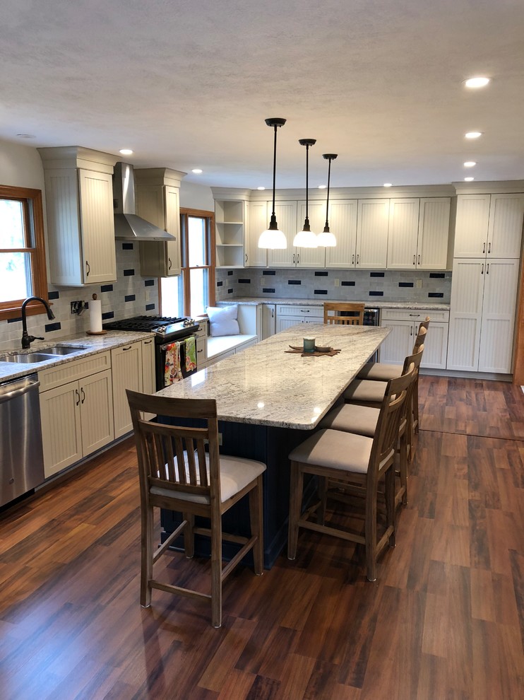 Eat-in kitchen - large transitional l-shaped vinyl floor and brown floor eat-in kitchen idea with an undermount sink, recessed-panel cabinets, blue cabinets, granite countertops, multicolored backsplash, ceramic backsplash, stainless steel appliances, an island and multicolored countertops