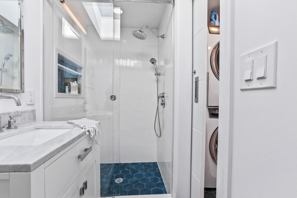 Photo of a medium sized contemporary ensuite bathroom in New York with white walls, a coffered ceiling, shaker cabinets, grey cabinets, a built-in bath, a shower/bath combination, a two-piece toilet, white tiles, ceramic tiles, ceramic flooring, a submerged sink, quartz worktops, blue floors, a sliding door, grey worktops, an enclosed toilet, a single sink and a freestanding vanity unit.