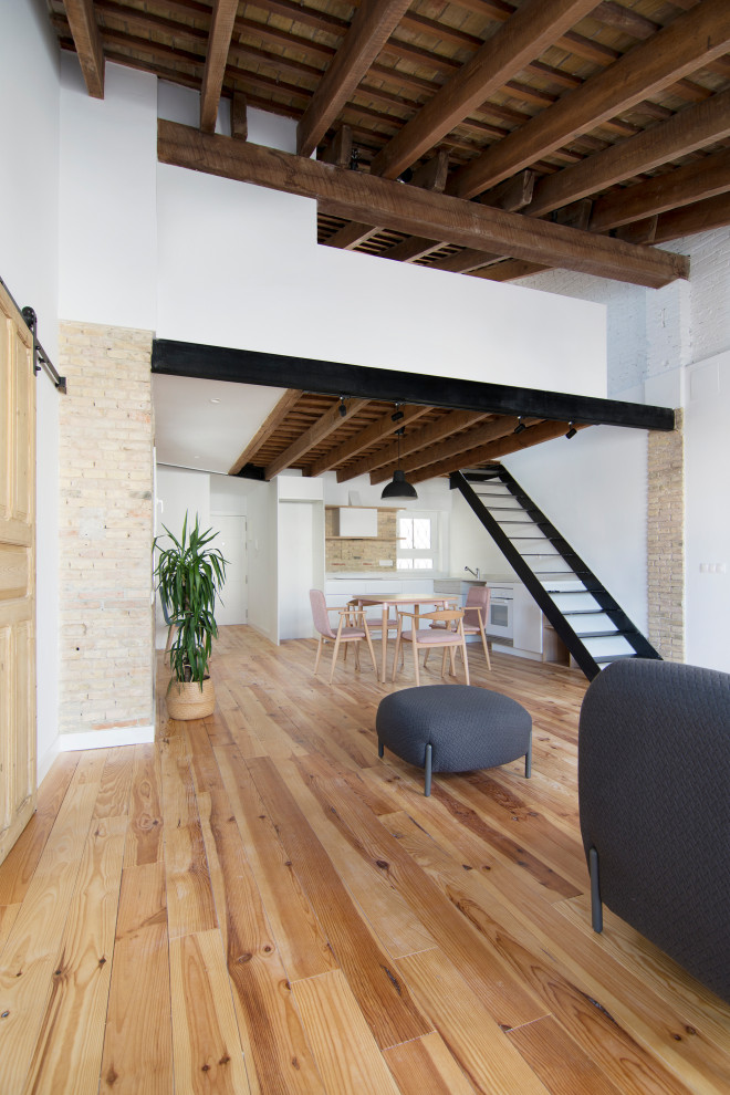 Idee per un piccolo soggiorno stile rurale con pavimento in legno massello medio, travi a vista e pareti in mattoni