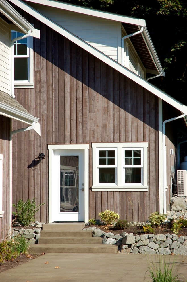 Large traditional two-storey beige house exterior in Seattle with wood siding, a gable roof and a shingle roof.