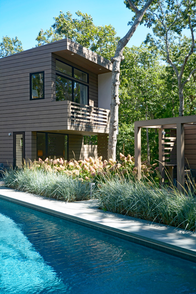 This is an example of a contemporary backyard rectangular pool in New York.