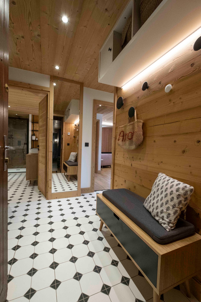 Idée de décoration pour un petit hall d'entrée chalet en bois avec un mur blanc, un sol en carrelage de céramique, une porte simple, une porte en bois brun, un sol blanc et un plafond en bois.