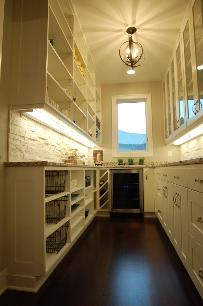 Design ideas for a small transitional galley kitchen pantry in Other with shaker cabinets, white cabinets, granite benchtops, white splashback, stainless steel appliances, dark hardwood floors and no island.