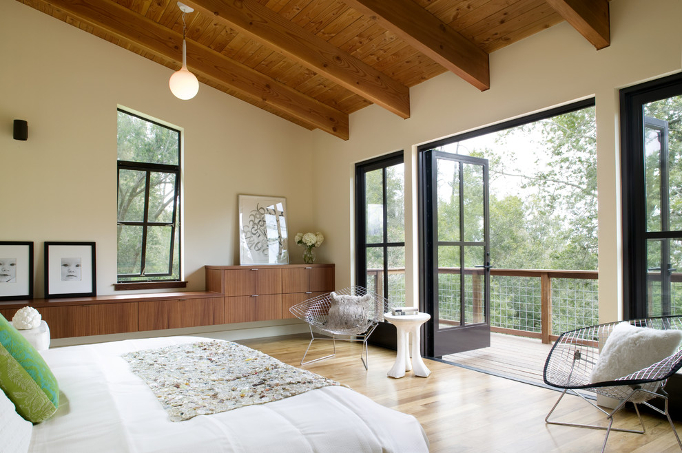 Example of a large trendy master light wood floor bedroom design in San Francisco with beige walls and no fireplace