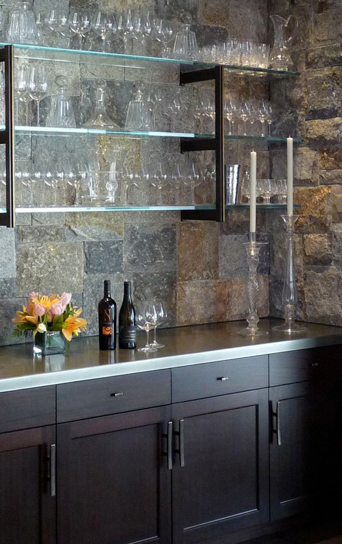 Photo of a modern home bar in New York with flat-panel cabinets, dark wood cabinets and zinc benchtops.