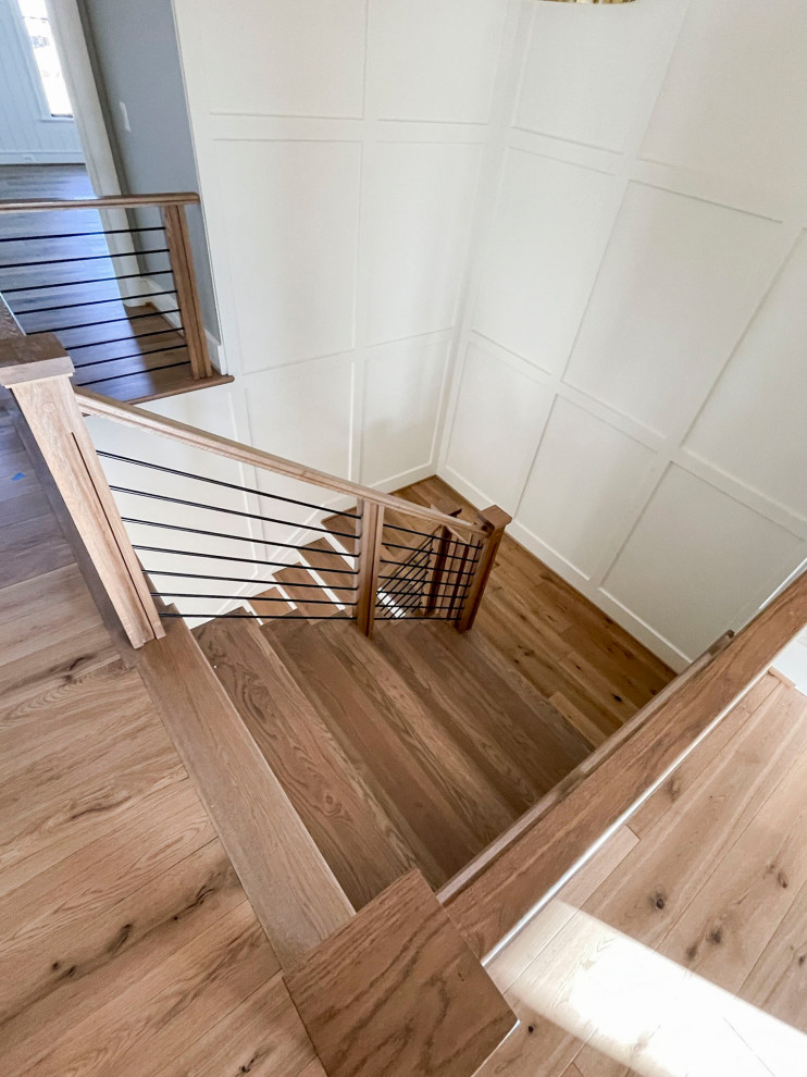 Стильный дизайн: большая деревянная лестница на больцах в стиле ретро с деревянными ступенями и перилами из смешанных материалов - последний тренд