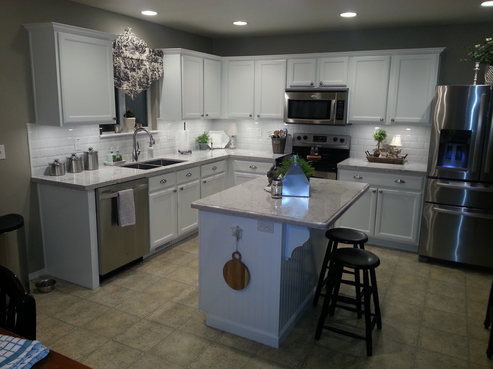 Eat-in kitchen - mid-sized transitional l-shaped ceramic tile and brown floor eat-in kitchen idea in Austin with a double-bowl sink, shaker cabinets, white cabinets, granite countertops, white backsplash, subway tile backsplash, stainless steel appliances and an island