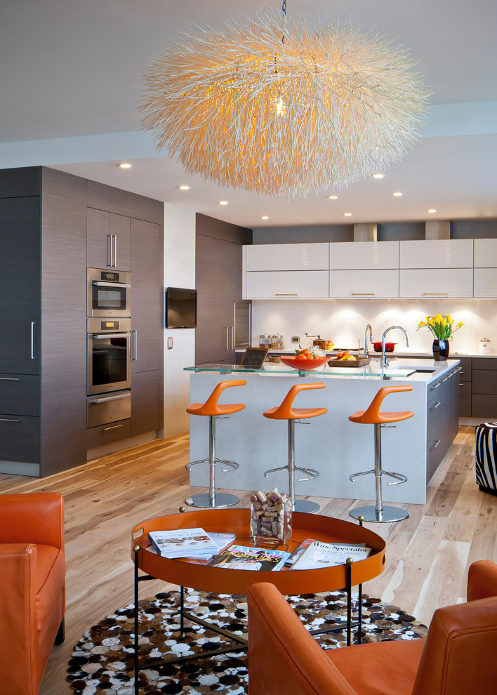 This is an example of a contemporary kitchen in San Francisco with flat-panel cabinets, grey cabinets, glass benchtops, white splashback and stainless steel appliances.