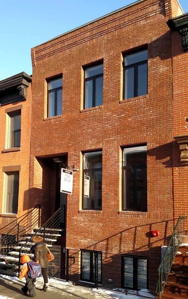 Mid-sized traditional three-storey brick brown townhouse exterior in Orange County with a flat roof.