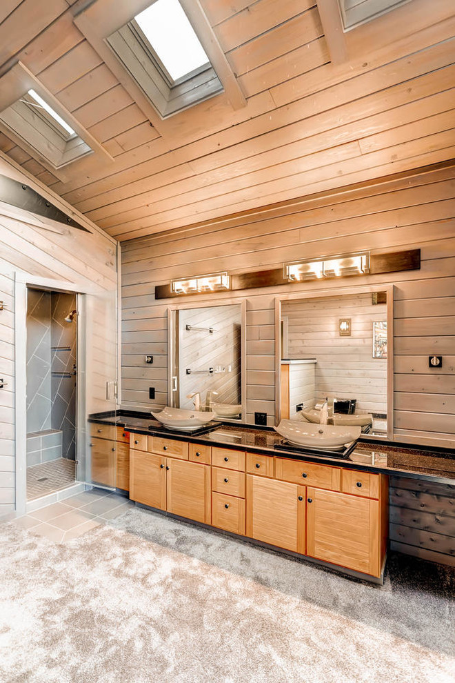 Inspiration for a mid-sized rustic master black tile and cement tile concrete floor corner shower remodel in Denver with flat-panel cabinets, light wood cabinets, a one-piece toilet, brown walls, a vessel sink and quartzite countertops