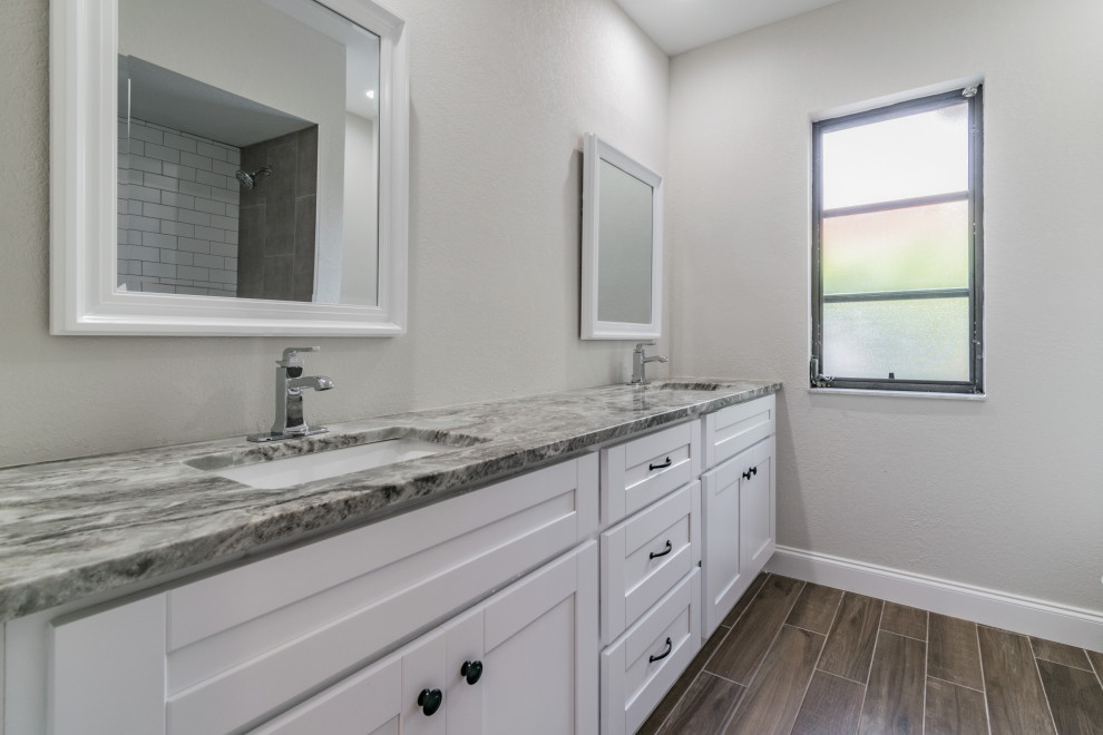 This is an example of an eclectic kids bathroom in Tampa with shaker cabinets, white cabinets, an open shower, white tile, wood-look tile, granite benchtops, an open shower, multi-coloured benchtops, a double vanity and a built-in vanity.