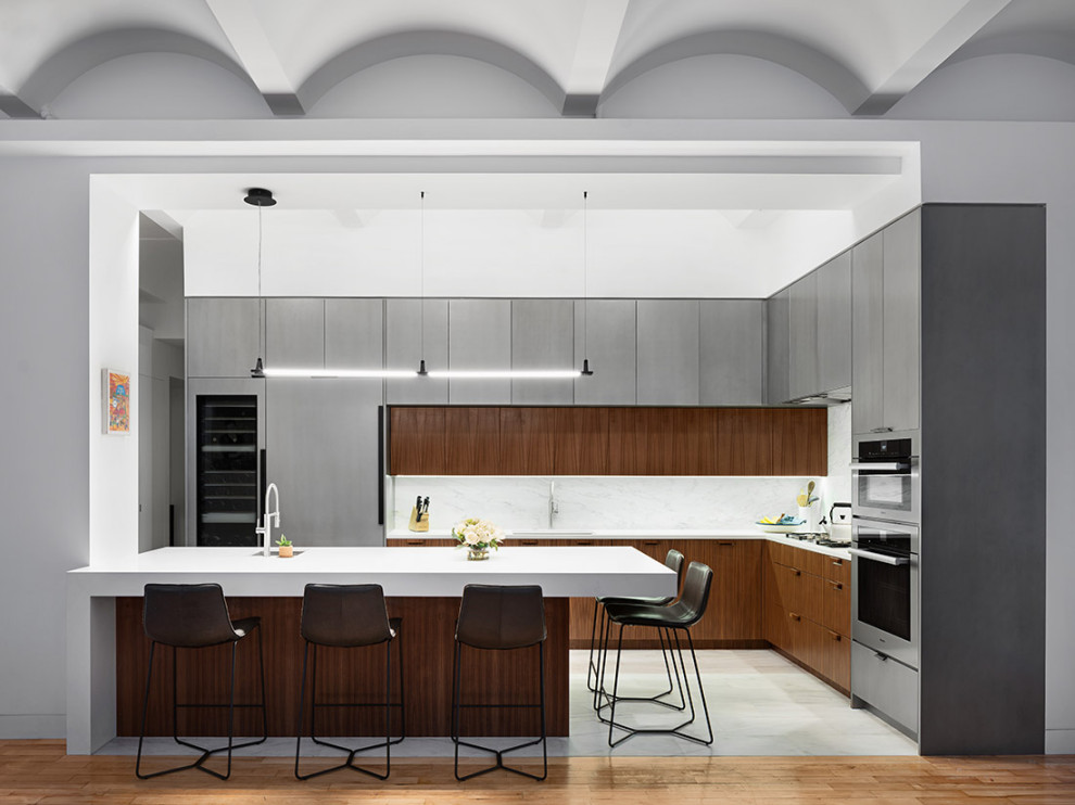 Inspiration for a large contemporary l-shaped eat-in kitchen in New York with an undermount sink, flat-panel cabinets, dark wood cabinets, quartz benchtops, white splashback, stone slab splashback, stainless steel appliances, marble floors, with island, grey floor and white benchtop.