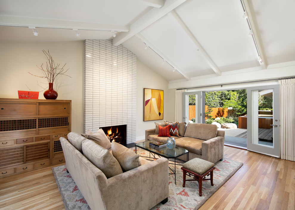 Photo of a midcentury formal living room in Santa Barbara with beige walls, light hardwood floors, a standard fireplace and a tile fireplace surround.