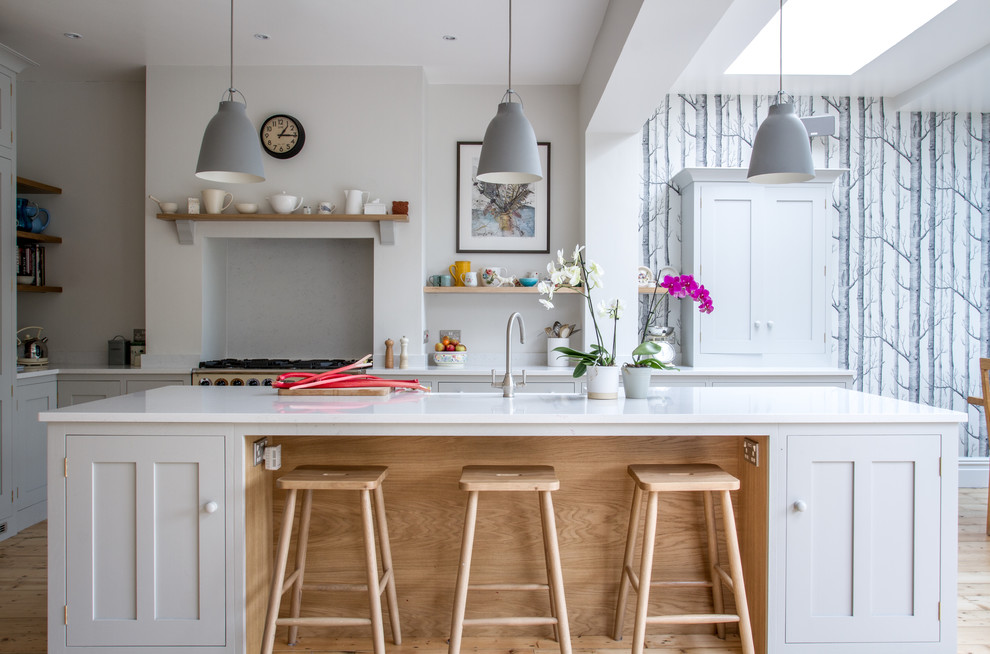 Photo of a large scandinavian l-shaped eat-in kitchen in Other with with island, a farmhouse sink, shaker cabinets, white cabinets, quartz benchtops and coloured appliances.
