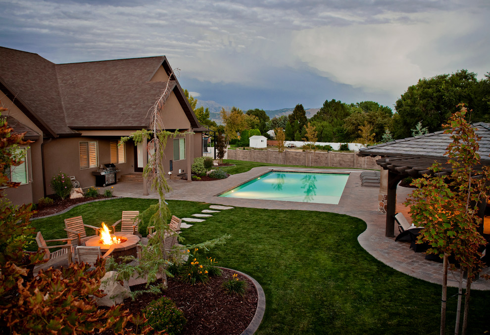 Design ideas for a large mediterranean backyard patio in Salt Lake City with a fire feature, concrete pavers and no cover.