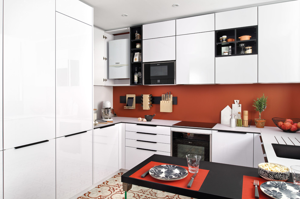 Inspiration for a small modern u-shaped eat-in kitchen in Surrey with a single-bowl sink, flat-panel cabinets, white cabinets, laminate benchtops, orange splashback, stainless steel appliances, terra-cotta floors, a peninsula, multi-coloured floor and white benchtop.