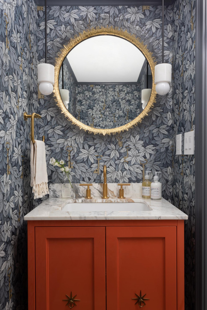 Inspiration for a small transitional powder room in New York with shaker cabinets, orange cabinets, blue walls, an undermount sink, quartzite benchtops, grey benchtops, a freestanding vanity and wallpaper.