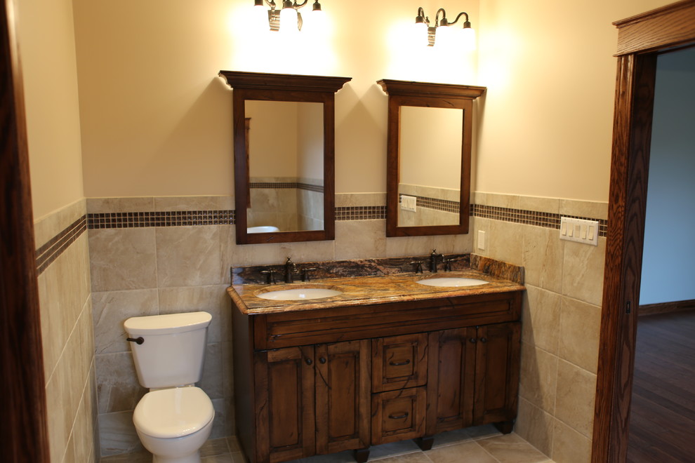 Mid-sized country master bathroom in Chicago with an undermount sink, raised-panel cabinets, medium wood cabinets, granite benchtops, a claw-foot tub, an alcove shower, a two-piece toilet, brown tile, brown walls, ceramic tile and ceramic floors.