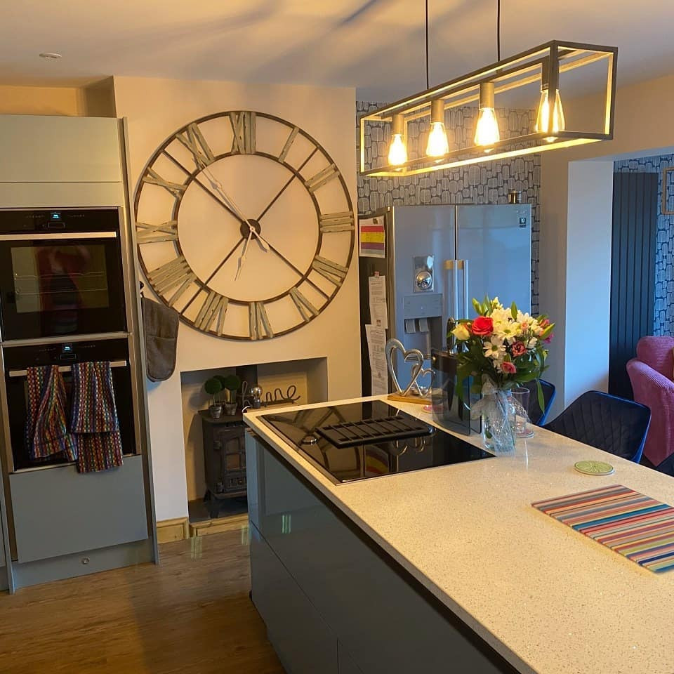 Design ideas for a medium sized contemporary open plan kitchen with a submerged sink, flat-panel cabinets, turquoise cabinets, quartz worktops, white splashback, metro tiled splashback, integrated appliances, vinyl flooring, an island, brown floors, white worktops and a feature wall.