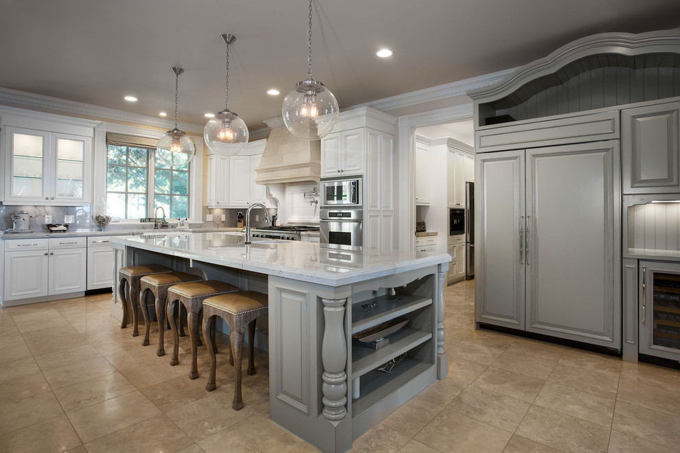 This is an example of a large traditional l-shaped separate kitchen in Salt Lake City with a farmhouse sink, raised-panel cabinets, white cabinets, marble benchtops, grey splashback, stone slab splashback, panelled appliances, travertine floors, with island, brown floor and grey benchtop.