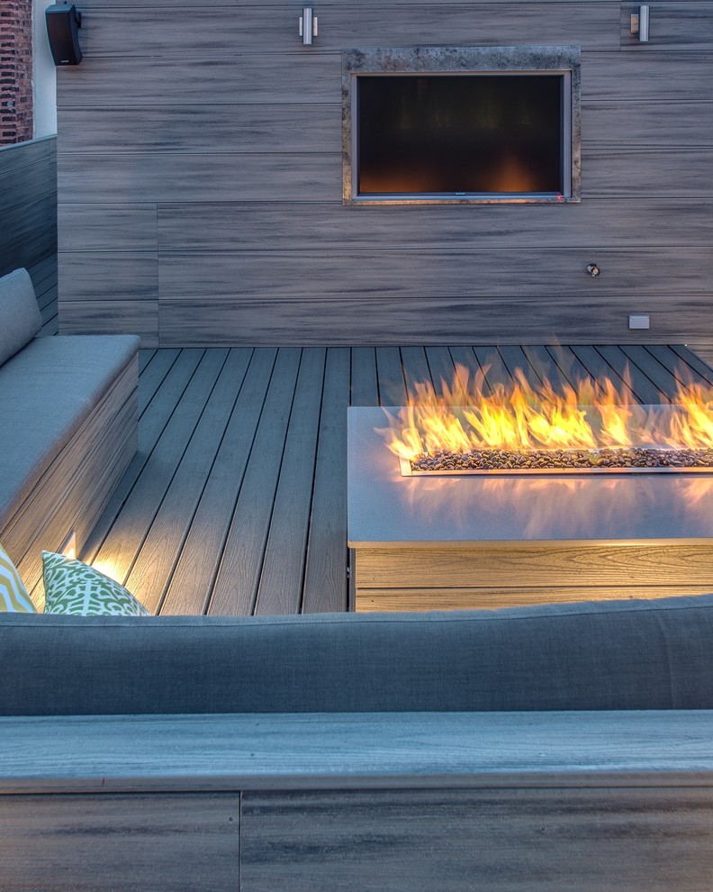 This is an example of an expansive modern rooftop deck in Chicago with a fire feature and no cover.