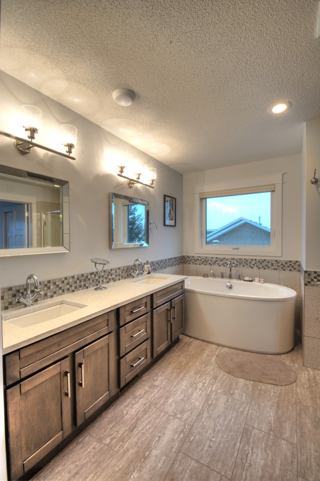 Mid-sized transitional master bathroom with shaker cabinets, dark wood cabinets, a freestanding tub, an alcove shower, multi-coloured tile, mosaic tile, white walls, an undermount sink, multi-coloured floor and a hinged shower door.