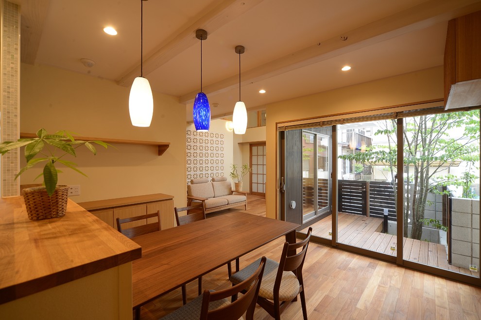 This is an example of an asian open plan dining in Other with beige walls, medium hardwood floors and brown floor.