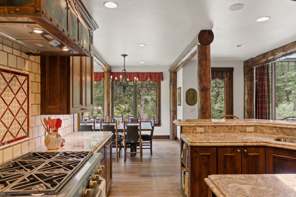 Example of a mountain style open concept kitchen design with medium tone wood cabinets, granite countertops and stainless steel appliances