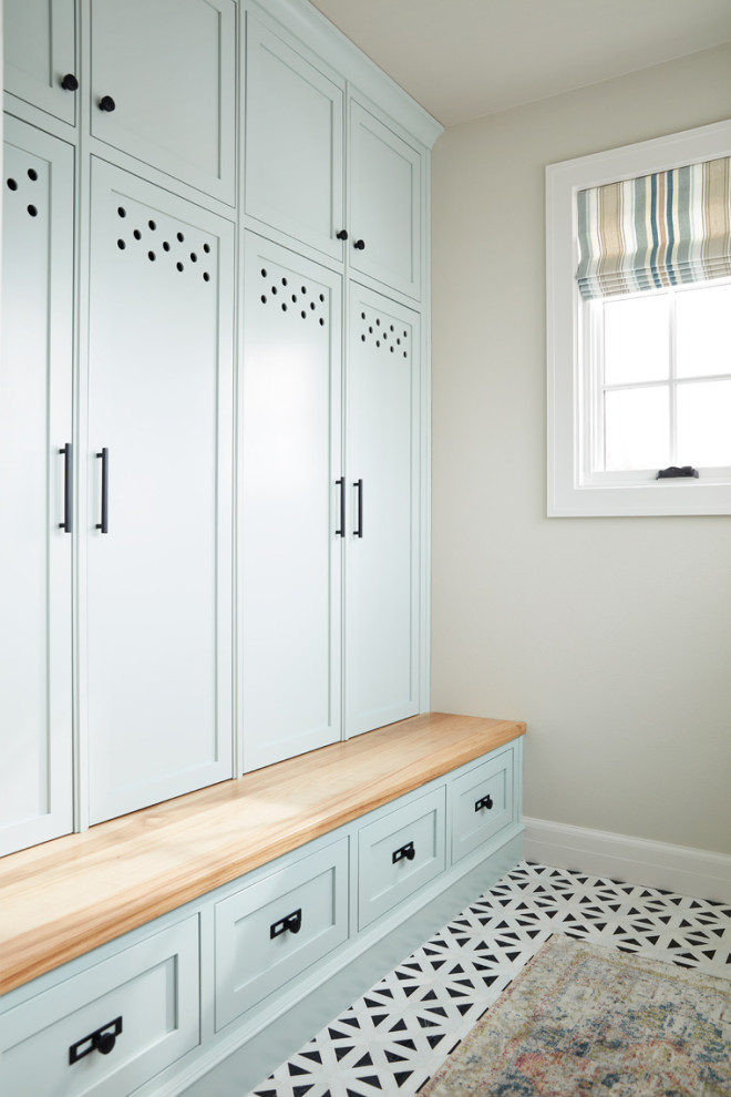 This is an example of a mid-sized transitional dedicated laundry room with recessed-panel cabinets and blue cabinets.