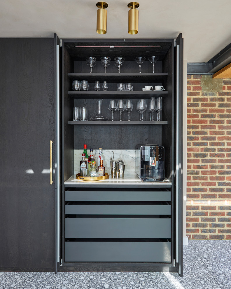 Photo of a medium sized contemporary l-shaped home bar in London with flat-panel cabinets and a feature wall.