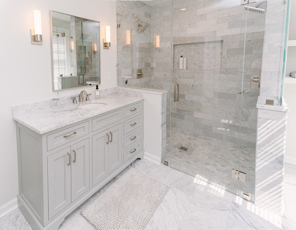 Inspiration for a large transitional bathroom in Cincinnati with recessed-panel cabinets, grey cabinets, a curbless shower, gray tile, marble, white walls, marble floors, an undermount sink, marble benchtops, grey floor, a hinged shower door and grey benchtops.
