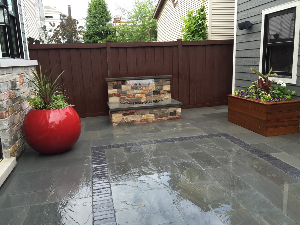 Photo of a small contemporary backyard patio in Chicago with a water feature and natural stone pavers.