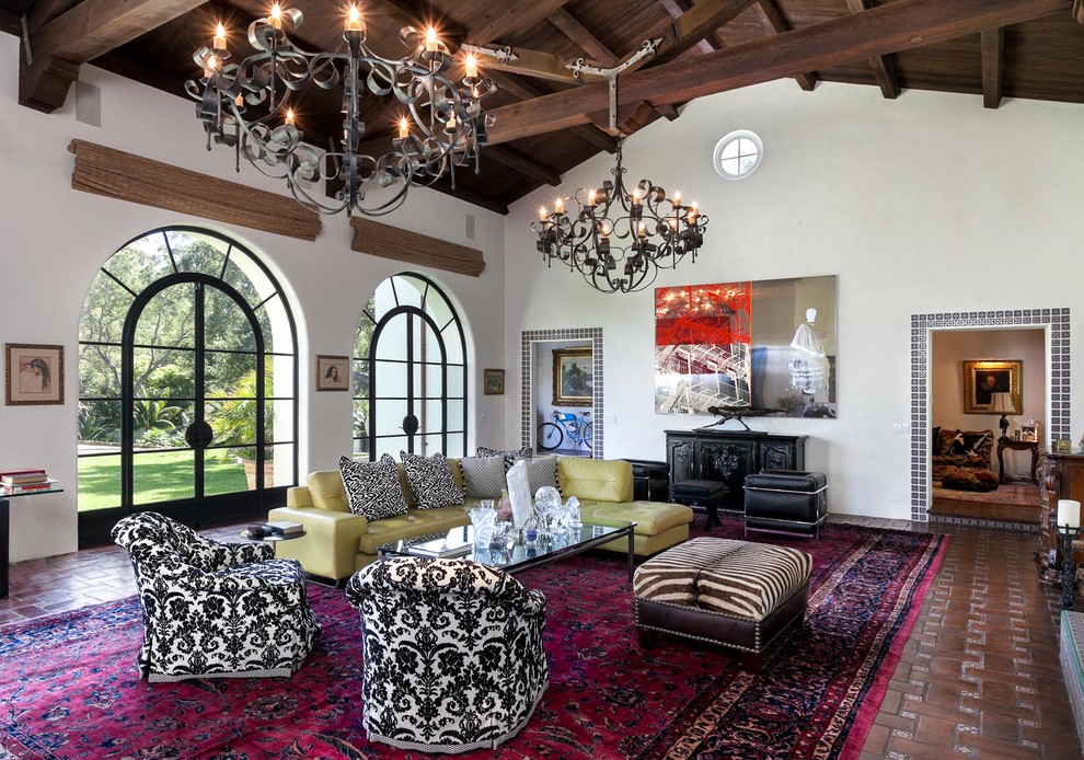 This is an example of a large mediterranean enclosed living room in Santa Barbara with brick floors and white walls.