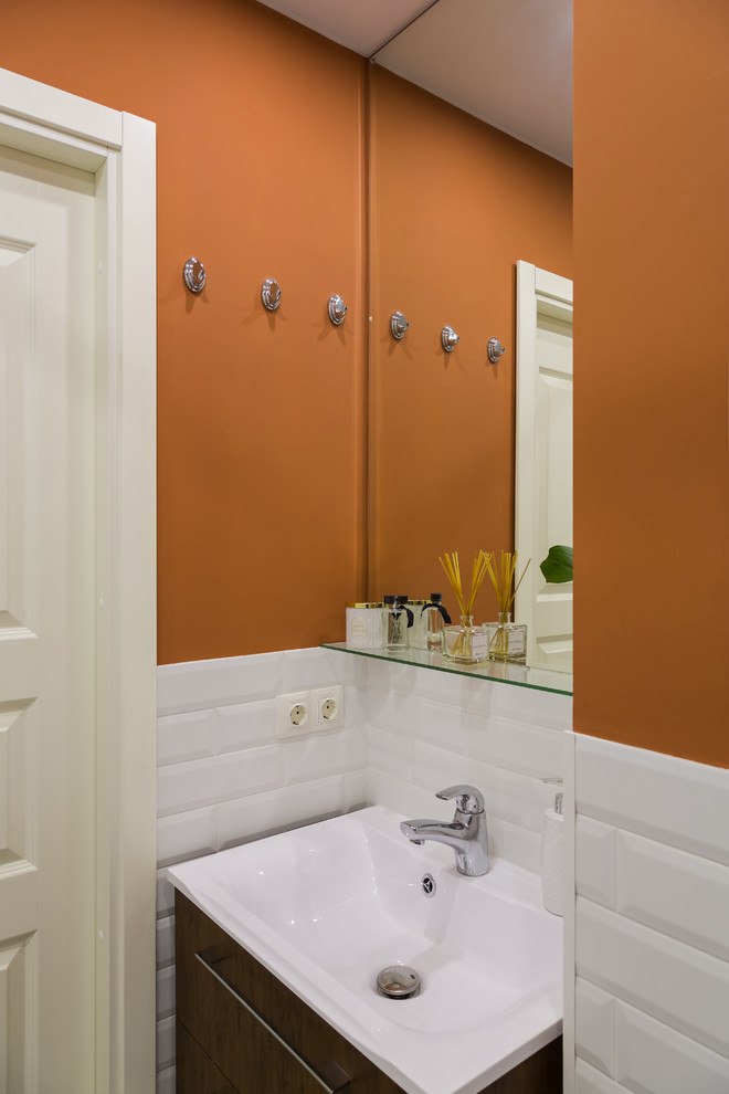 Inspiration for a small contemporary powder room in Saint Petersburg with white tile, porcelain tile, flat-panel cabinets, dark wood cabinets and orange walls.