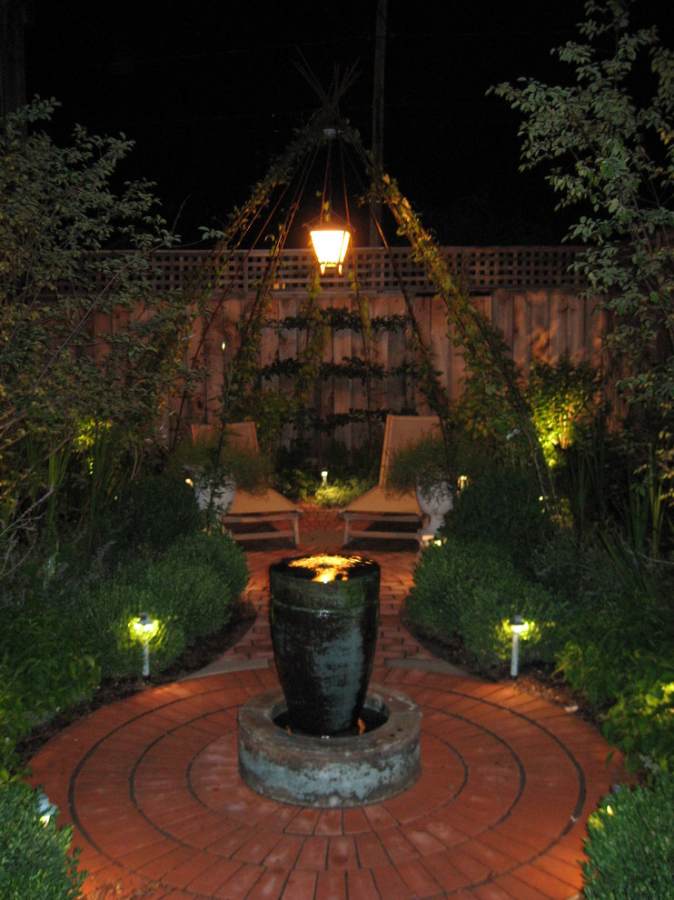 Photo of a mid-sized traditional backyard formal garden in New York with a water feature and brick pavers.