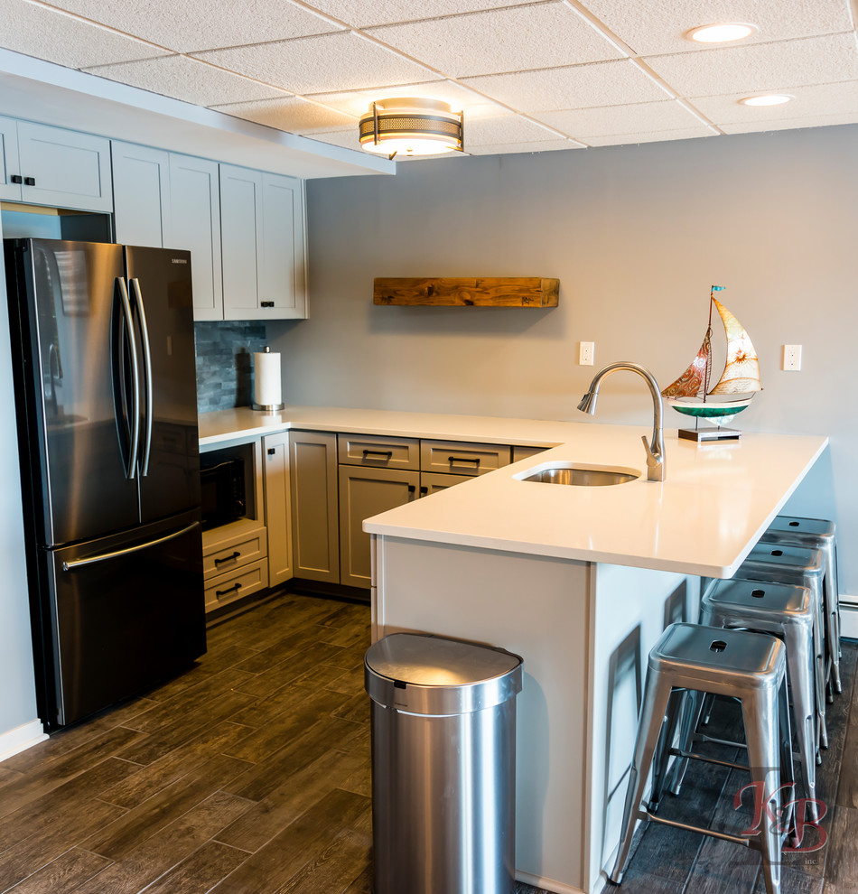 Eat-in kitchen - mid-sized transitional porcelain tile and brown floor eat-in kitchen idea with an undermount sink, recessed-panel cabinets, white cabinets, quartz countertops, gray backsplash, subway tile backsplash, stainless steel appliances, an island and white countertops
