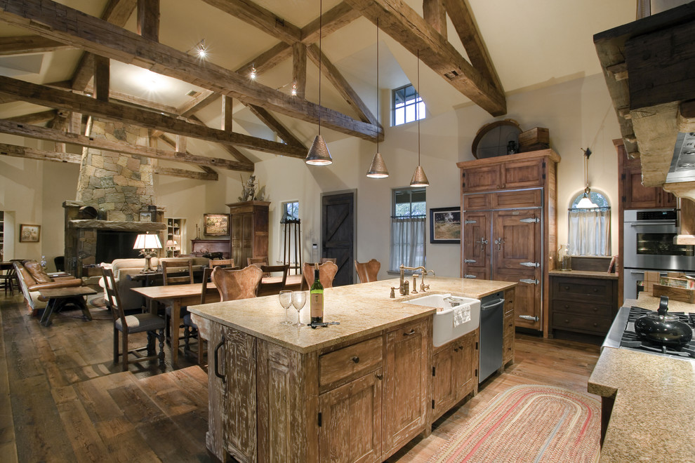 Large country l-shaped open plan kitchen in Austin with granite benchtops, a farmhouse sink, distressed cabinets, panelled appliances and with island.