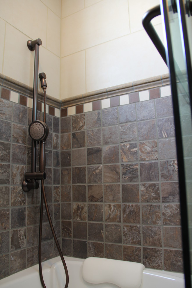 Inspiration for a transitional brown tile and porcelain tile porcelain tile tub/shower combo remodel in Columbus with a vessel sink, an undermount tub, a two-piece toilet, raised-panel cabinets, medium tone wood cabinets, granite countertops and beige walls