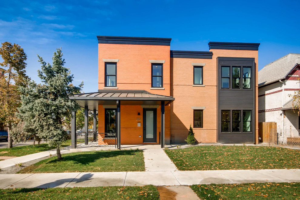 This is an example of a transitional two-storey brick red townhouse exterior in Denver with a flat roof.