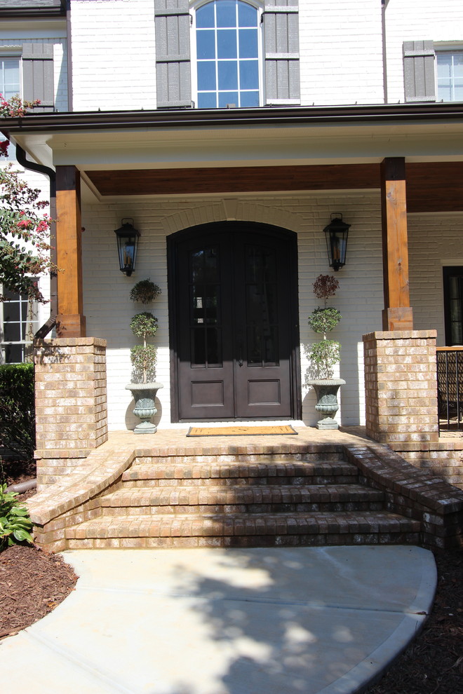 Photo of a mid-sized transitional front door in Atlanta with white walls, brick floors, a double front door and a metal front door.