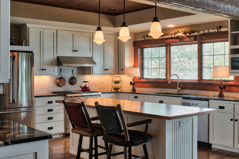 Inspiration for a mid-sized arts and crafts u-shaped eat-in kitchen in Minneapolis with an undermount sink, flat-panel cabinets, white cabinets, granite benchtops, white splashback, mosaic tile splashback, stainless steel appliances, medium hardwood floors, with island and brown floor.