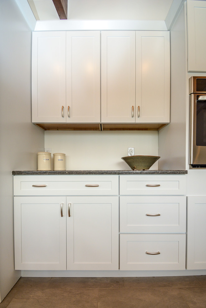 Inspiration for a mid-sized midcentury galley separate kitchen in Boston with a double-bowl sink, flat-panel cabinets, white cabinets, quartz benchtops, stainless steel appliances, ceramic floors, grey benchtop, no island and brown floor.