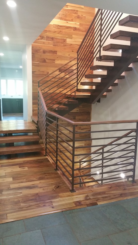 This is an example of a mid-sized modern wood u-shaped staircase in Other with open risers and metal railing.