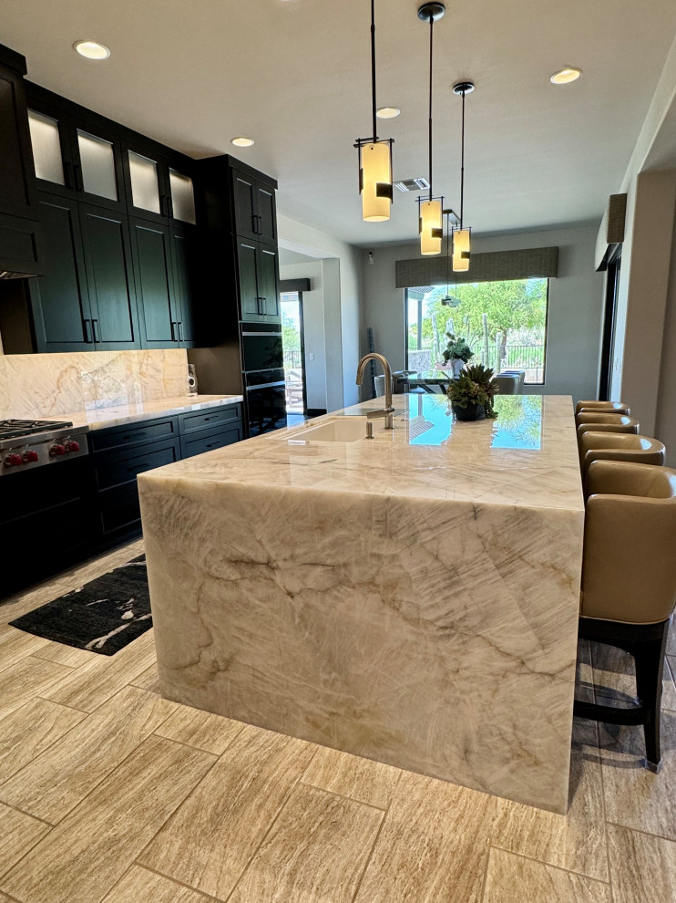 Large transitional l-shaped porcelain tile and beige floor kitchen pantry photo in Phoenix with an undermount sink, shaker cabinets, dark wood cabinets, quartzite countertops, beige backsplash, stone slab backsplash, paneled appliances, an island and beige countertops