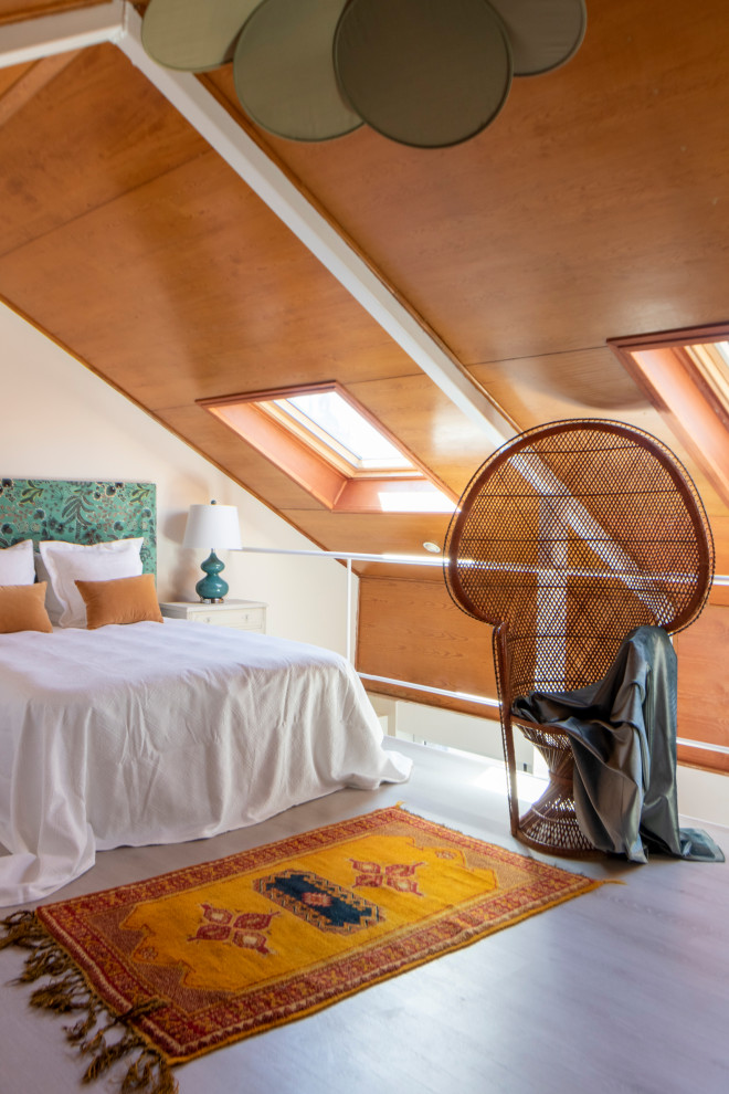 Foto di una camera da letto stile loft tradizionale di medie dimensioni con pareti bianche, pavimento in laminato e pavimento grigio